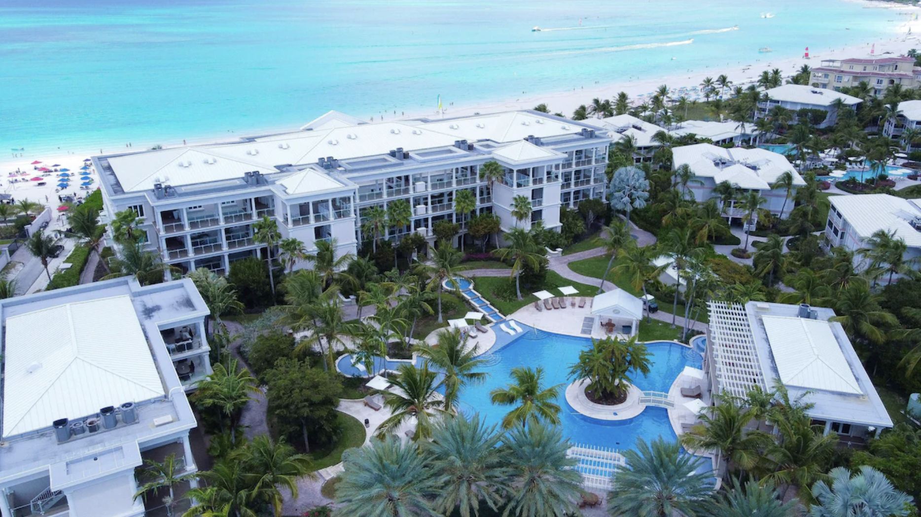 Aerial view of The Pinnacle on Grace Bay, the beachfront building with its gardens and lagoon pool behind